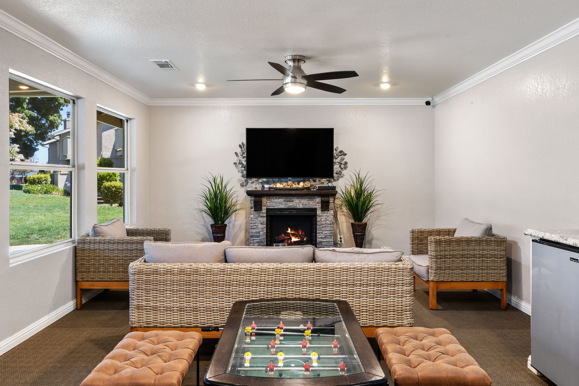 Clubhouse lounge with a stone fireplace, wicker seating and a foosball table