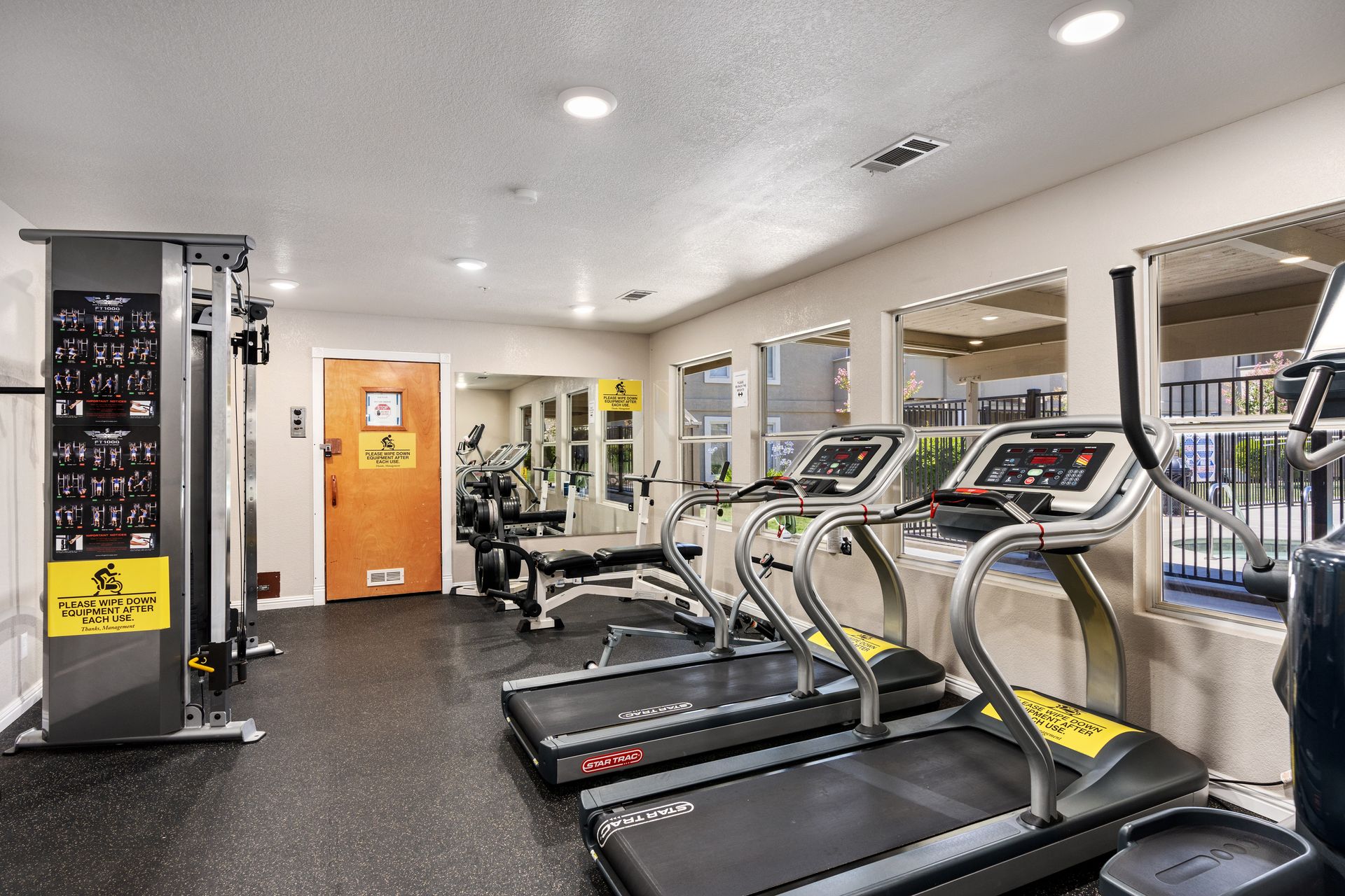 On-site fitness center with treadmills, a weight bench and a cable machine